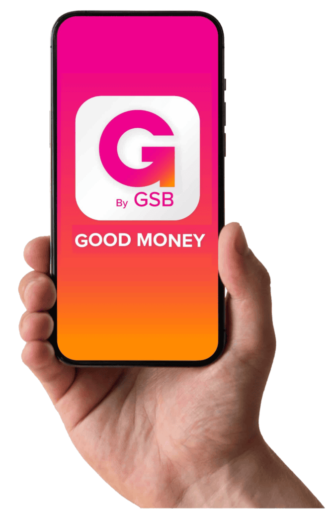 A hand is holding a smartphone displaying the "GOOD MONEY" app by GSB. The screen shows the app's logo, featuring a white "G" on a gradient background transitioning from pink to orange.