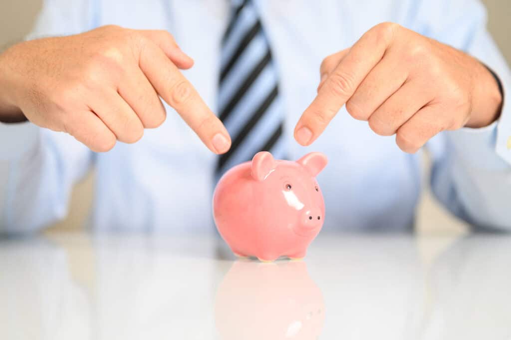 closeup businessman pointing piggy bank